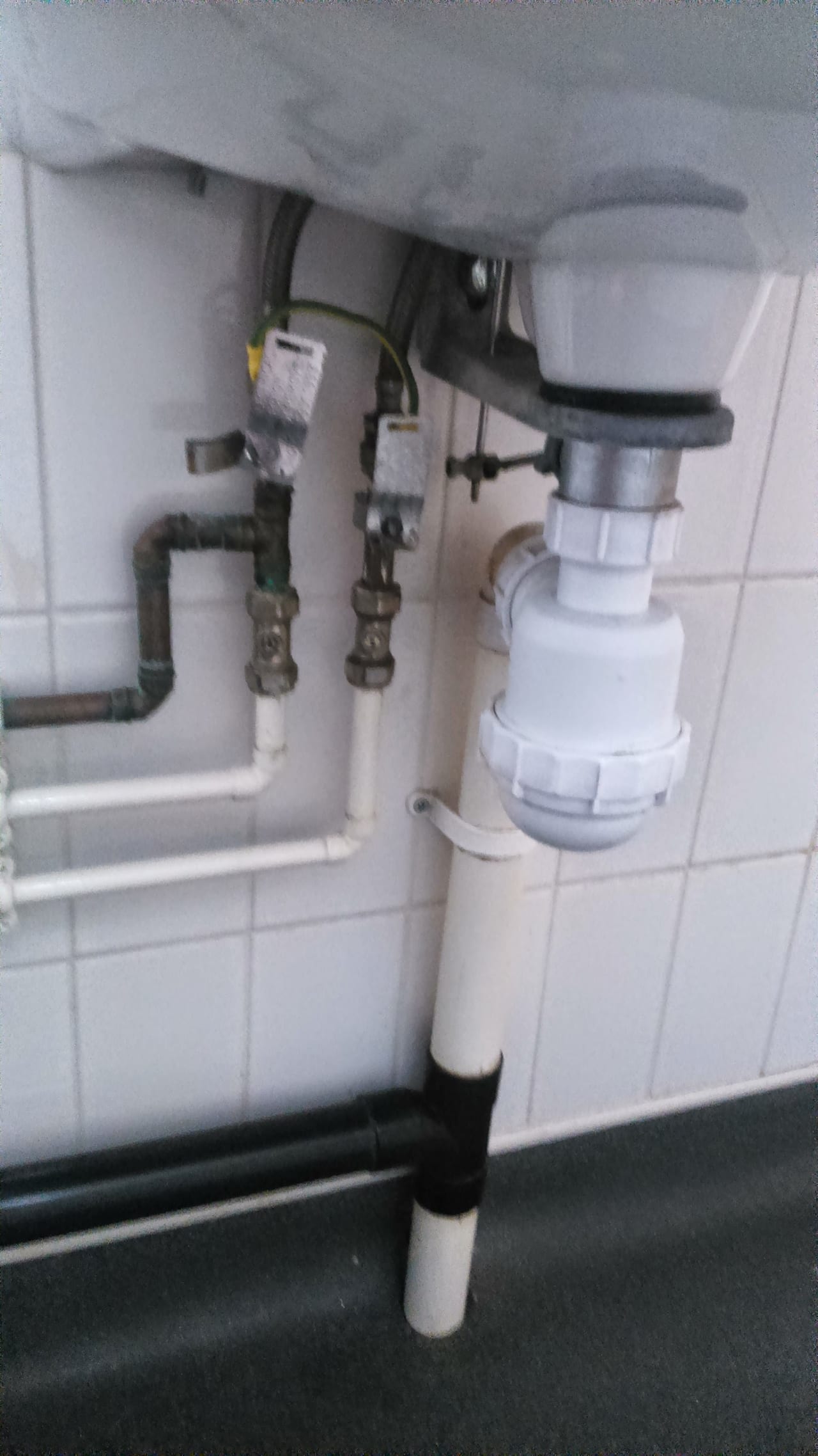 White sink drain trap and household supply pipework